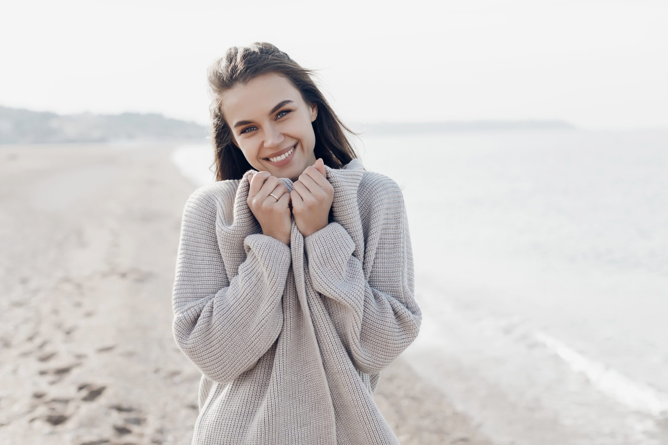 Na imagem está presente uma mulher com uma pele bonita e saudável em um dia frio.